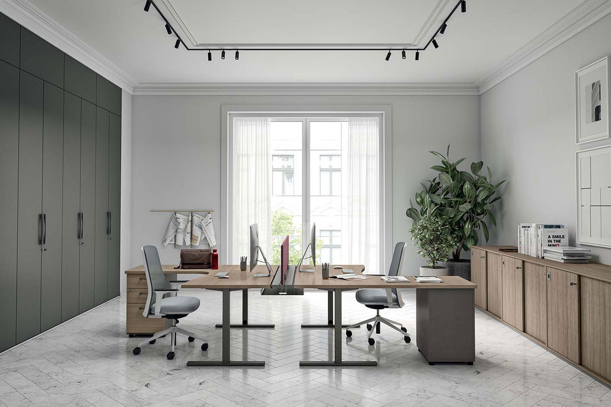 Sfeerbeeld van een kantoor met groene kastenwand en twee werkplekken in houtdecor op zwarte poten bij een raam