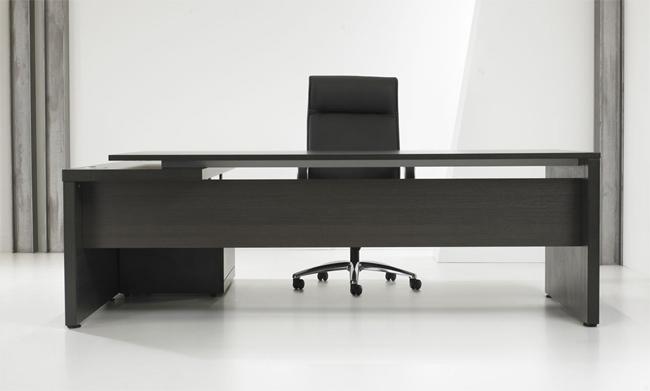 Het directiebureau in donker houtdecor frontaal, met een zwarte directiestoel erachter
