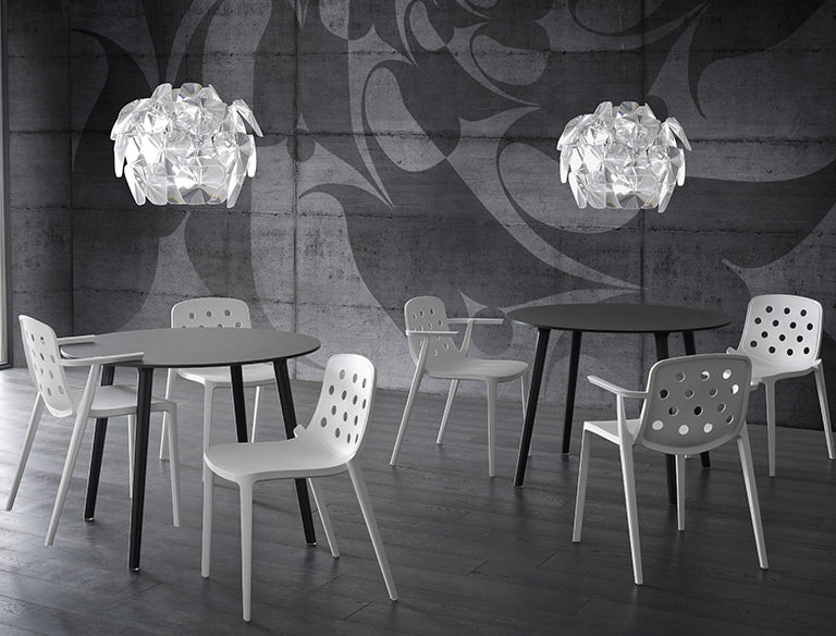 Witte Isidora stoelen aan ronde tafels onder grote hanglampen
