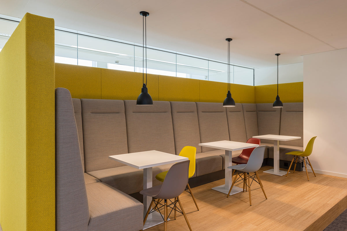 Base banken met hoge rug langs een wand in een kantine