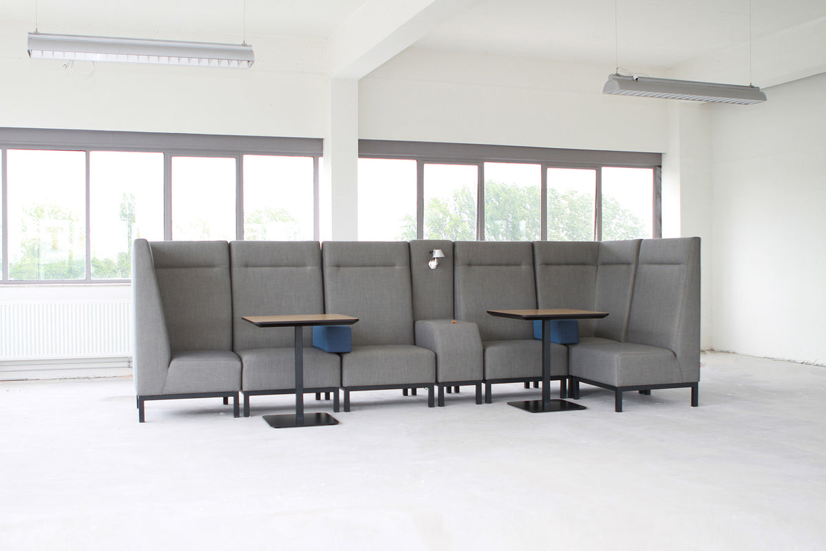 Base banken met hoge rug en tafels bij grote ramen