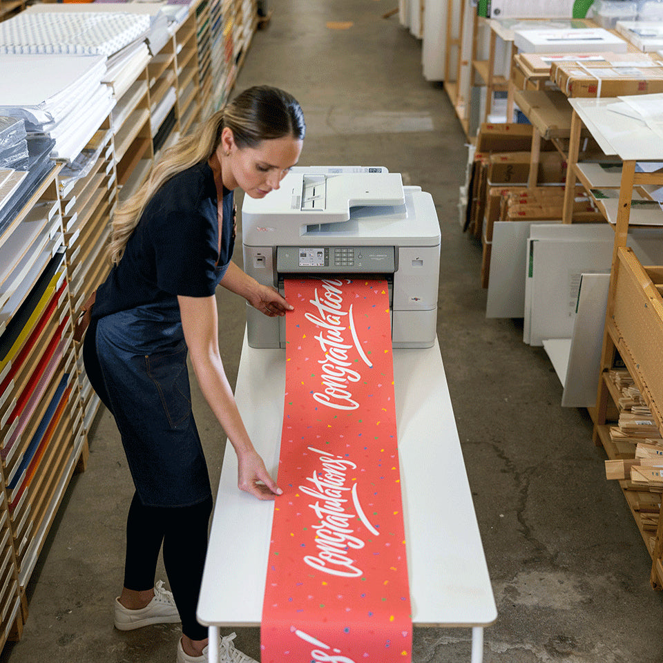 Medewerker bij de Brother MFC-J6959DW met een geprinte banner in een winkel