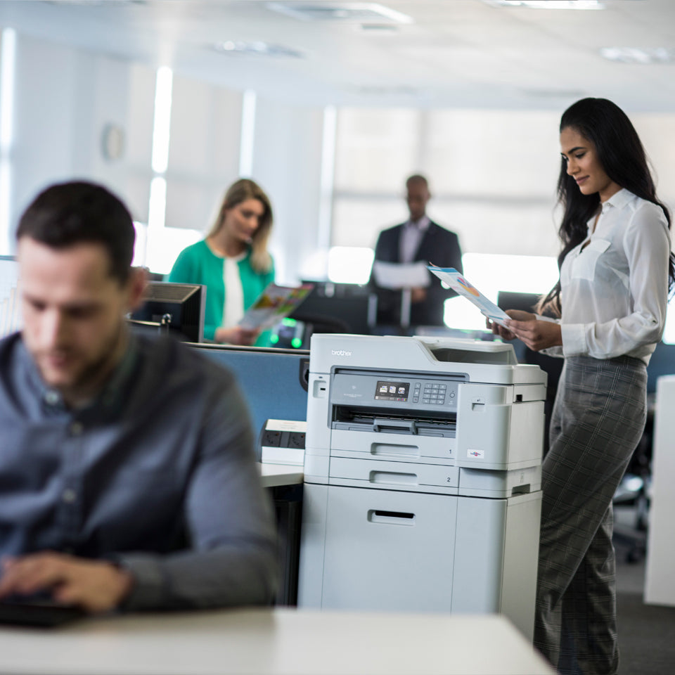 Kantoormedewerkers aan het werk met een printer op een Brother onderkast