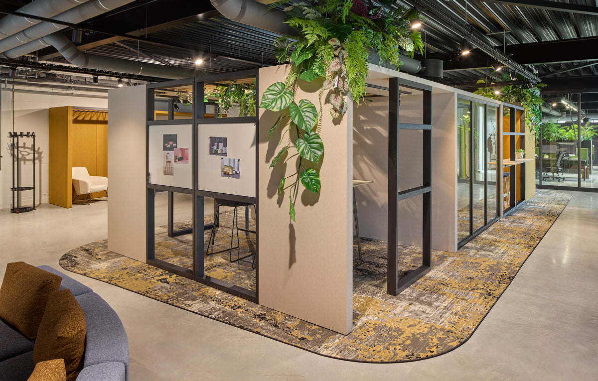 M+ Room met glazen wanden en planten in een open kantoor