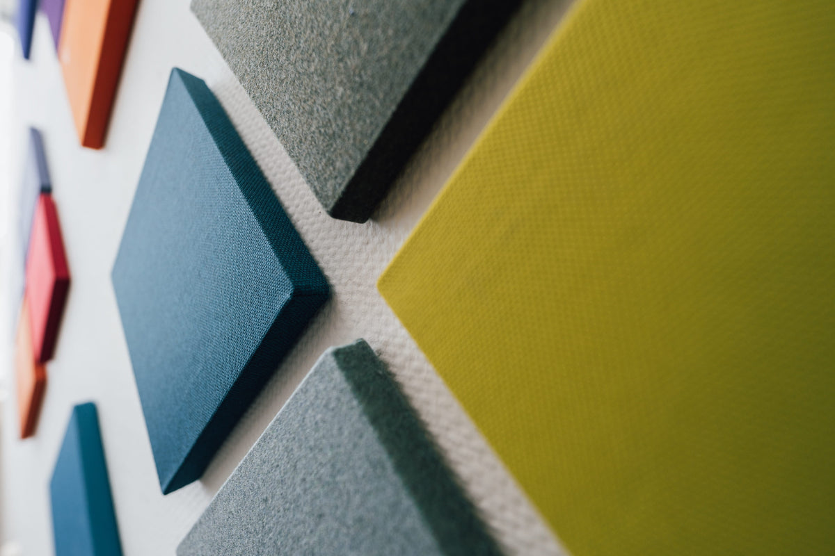 MUTE akoestische panelen in blauw, groen en limegroen aan een wand