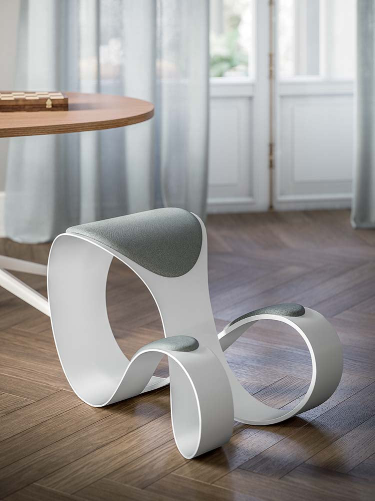Witte kunststof loungestoel met ronde, gebogen vorm in een kamer met houten vloer