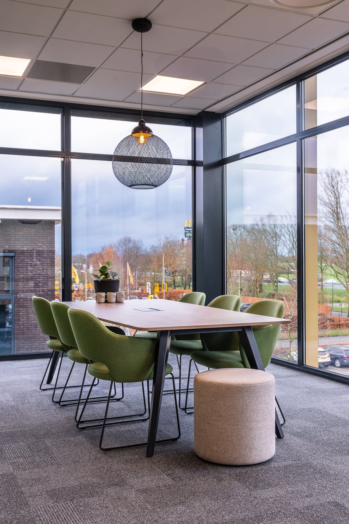 Swing stoelen in groen met poef aan tafel bij raampartij