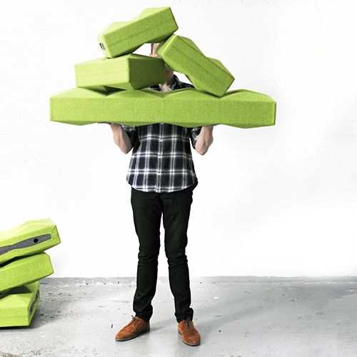Man draagt een stapel groene Fabricks-blokken