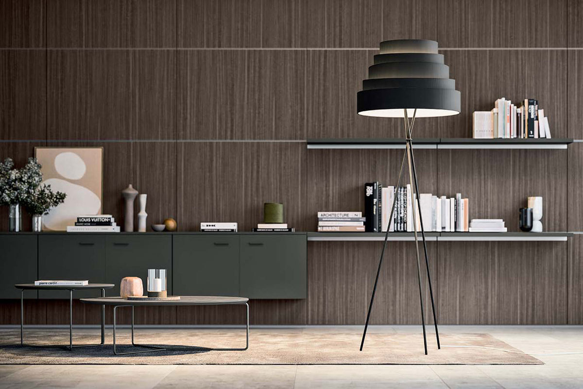 Staande lamp in een woonkamer naast een bank bij het raam