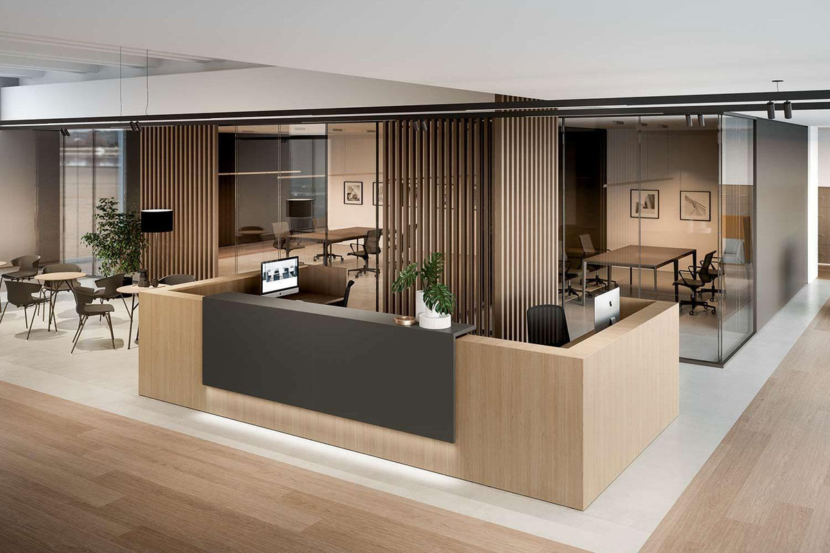 Kantoorlobby met een lange balie in hout en donker decor, met werkplekken op de achtergrond