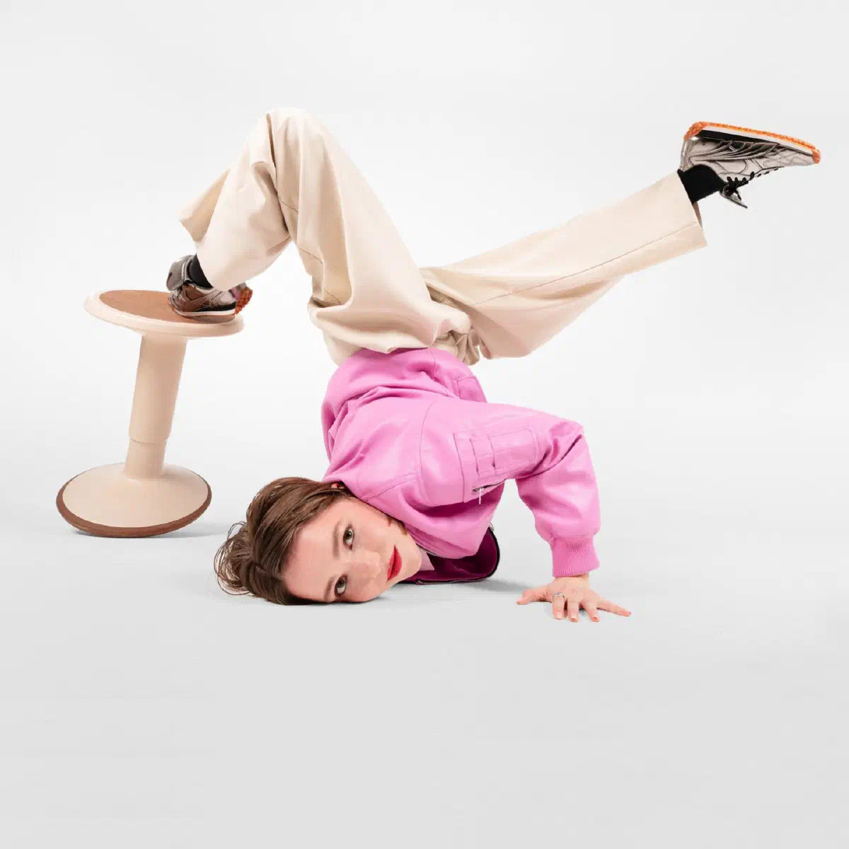 Se7en Charly LX008: beige zit-sta kruk met ronde zitting, taps kolom en ronde voet, naast een liggend model