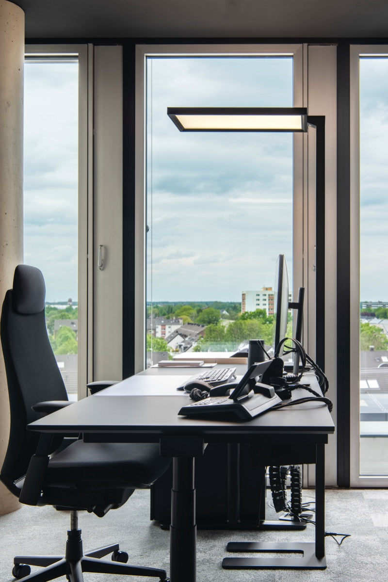 Vloerlamp Work naast een bureau in een kantoor met uitzicht