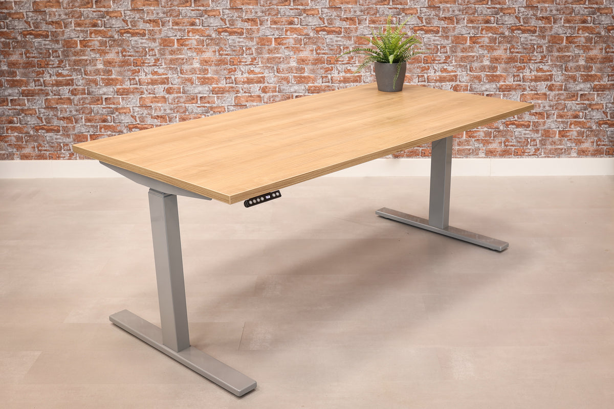 Elektrisch zit-sta bureau Ciao met blad in eikendecor op een grijs T-frame met bedieningspaneel