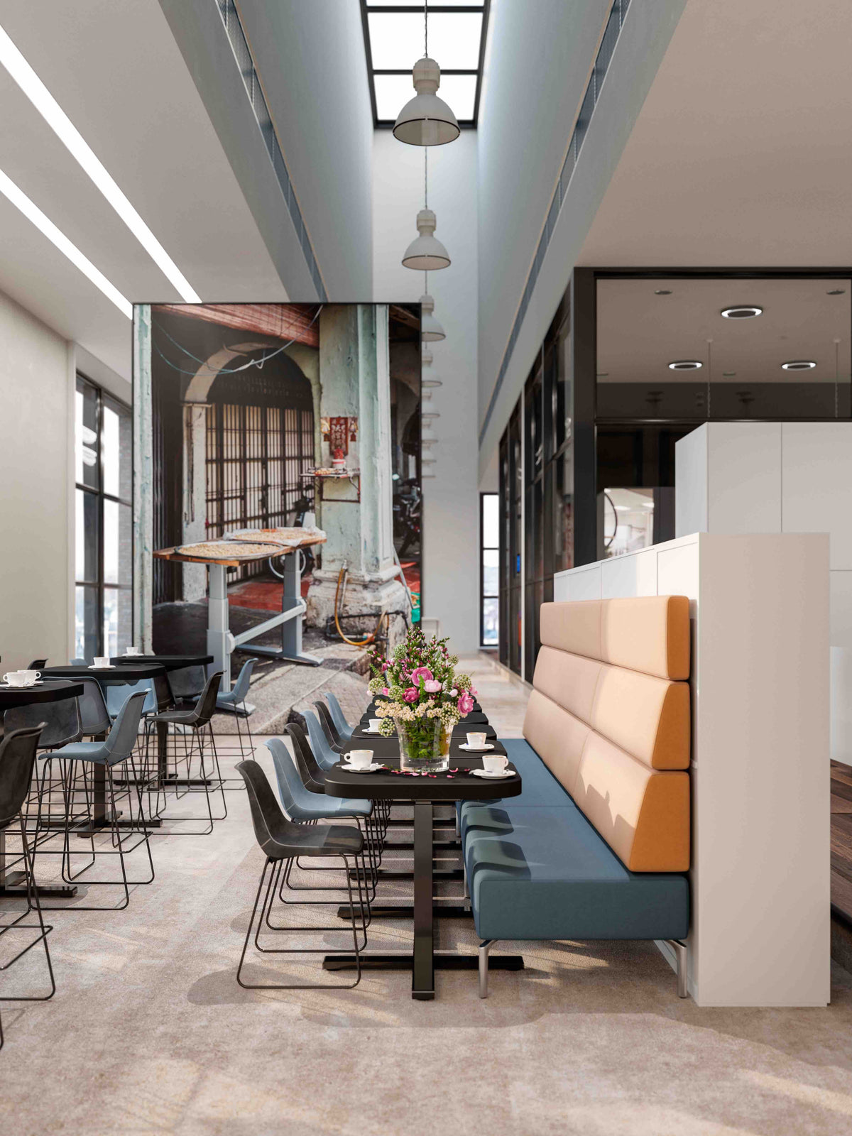 Kantoorlounge met bankjes en tafels in een lichte gang
