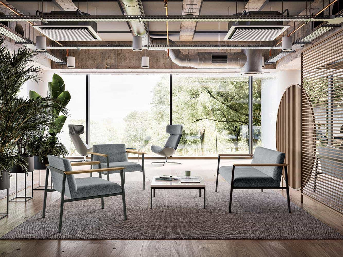 Ado fauteuils en bank bij hoge ramen met planten in een loungeopstelling