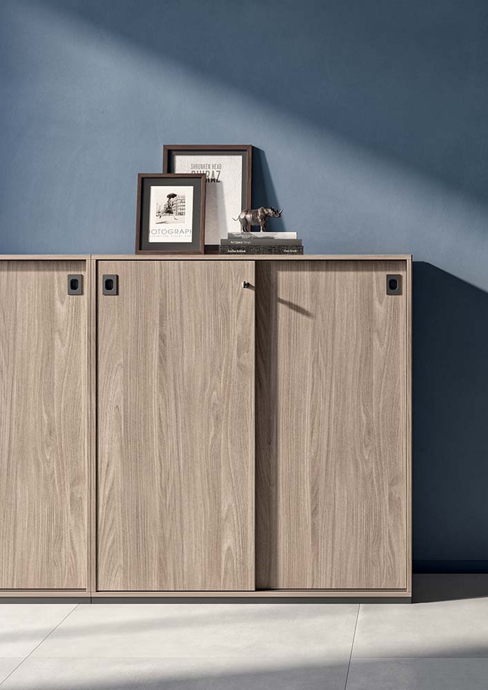 Q4 schuifdeurkast in licht hout met twee schuifdeuren, opgesteld tegen een blauwe wand
