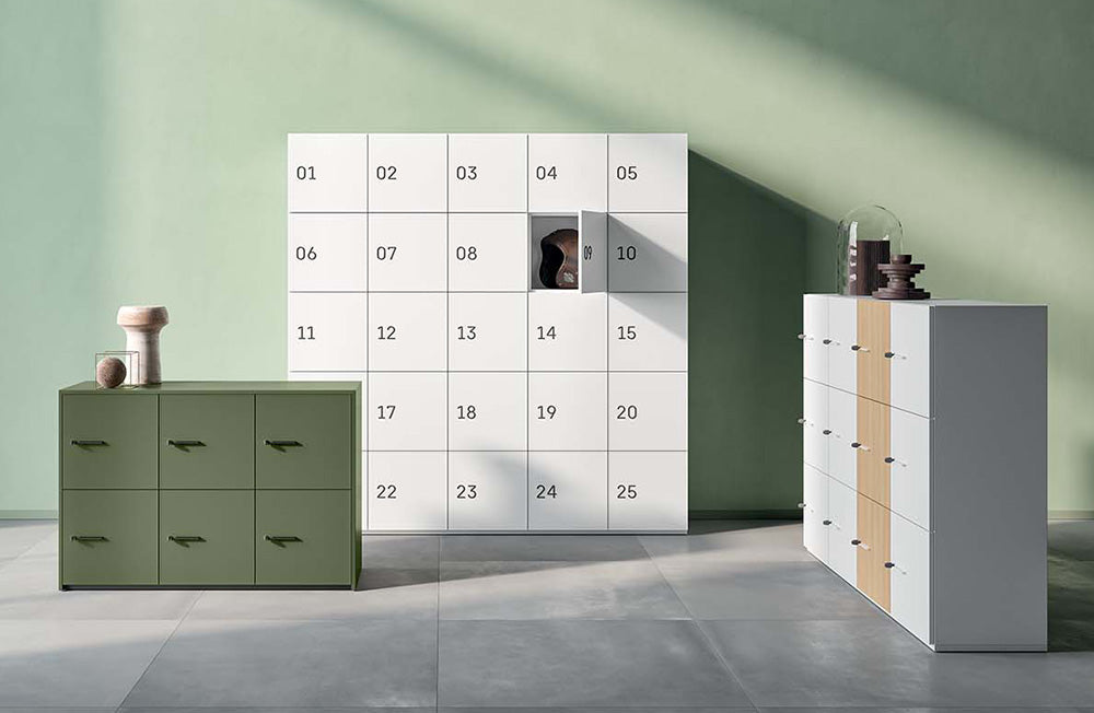 Lockerkasten in groen en wit met genummerde deurtjes tegen een groene wand