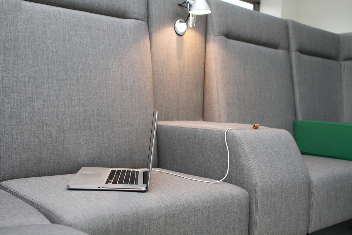 Base bank in grijs met laptop en wandlamp