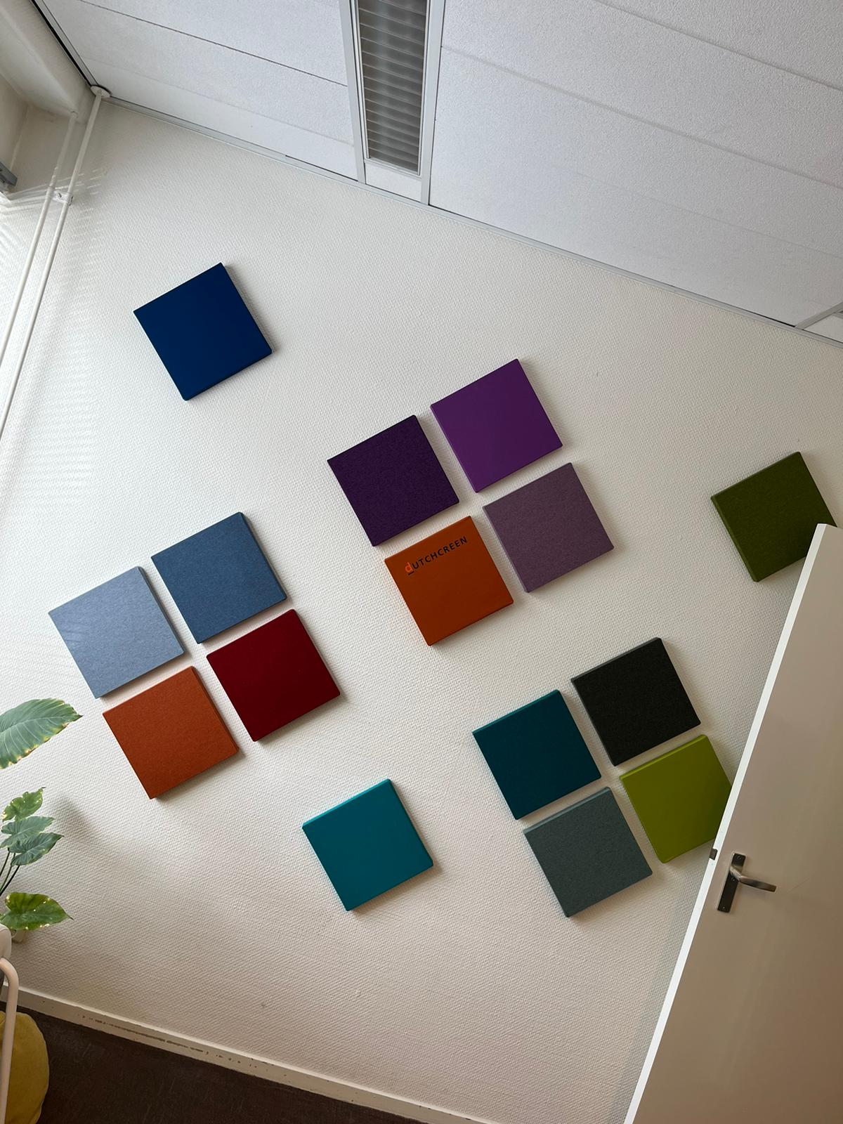 MUTE akoestische panelen: vierkante panelen in blauw, paars, rood, groen en grijs op een witte wand