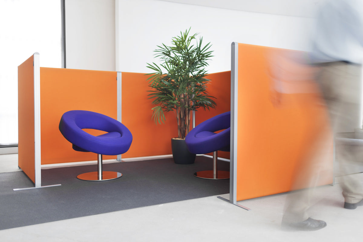 NOVU staande scheidingswanden in oranje, in hoekopstelling met twee paarse ronde fauteuils en een plant