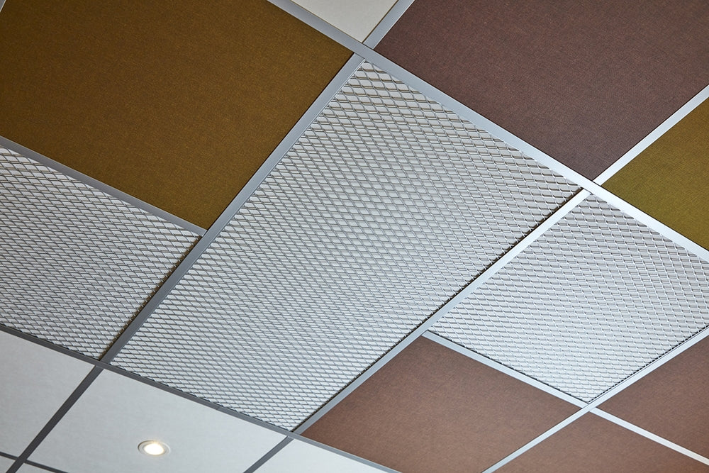 Systeemplafond van onderaf met drie decoratieve frames in ruitmotief tussen gekleurde akoestische tegels