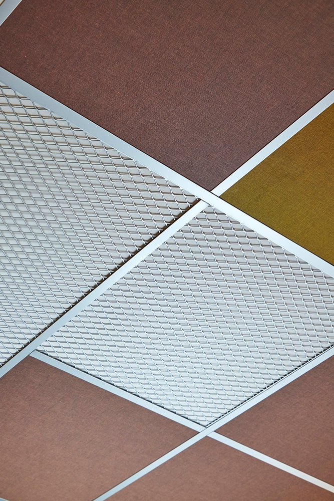 Zilverkleurig decoratief plafondframe met ruitmotief tussen okergele en roodbruine plafondtegels