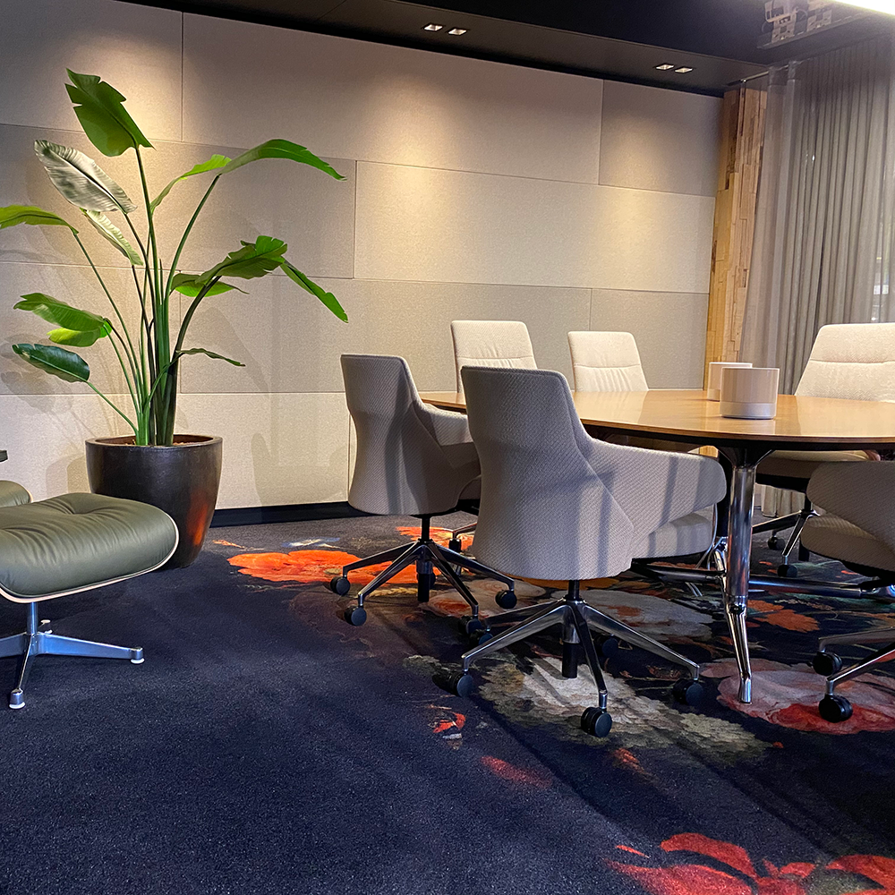 Sfeerbeeld van lichte akoestische wandpanelen in een vergaderruimte met tafel en beklede stoelen
