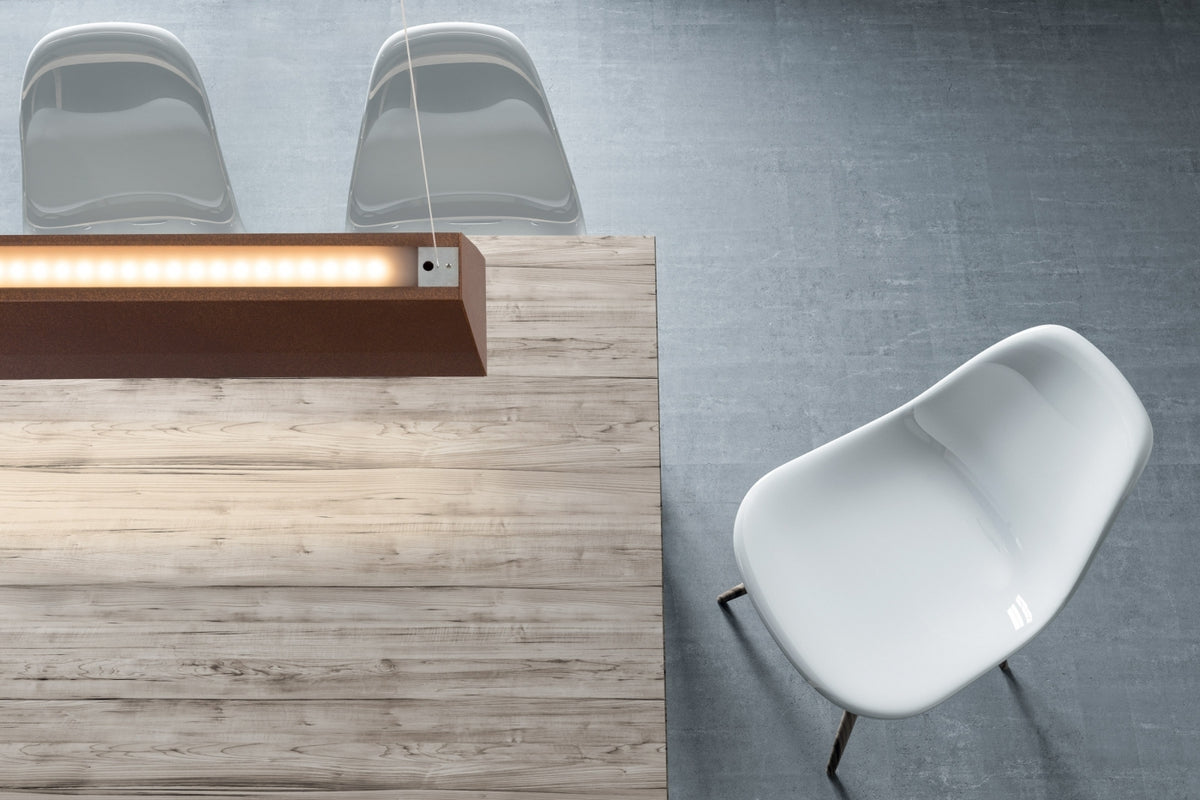 Twee lineaire hanglampen boven een balie in een ruimte met blauwe wand