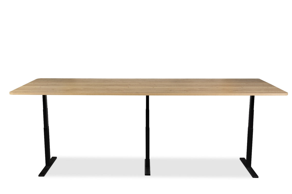 Elektrisch bureau Ciao XL met lang eikendecor blad op drie zwarte poten