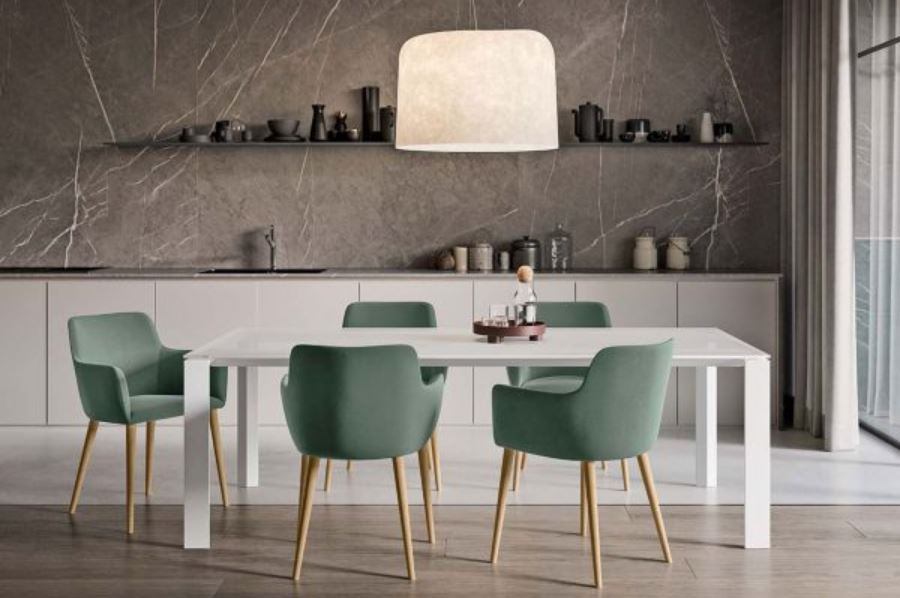 Pantry met groen gestoffeerde kuipstoelen op houten poten rond een witte tafel