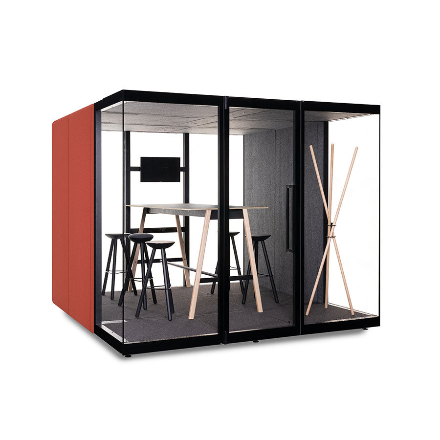 Ruime akoestische cabine met rood zijpaneel en glazen wanden, binnen een hoge tafel met krukken en wandscherm