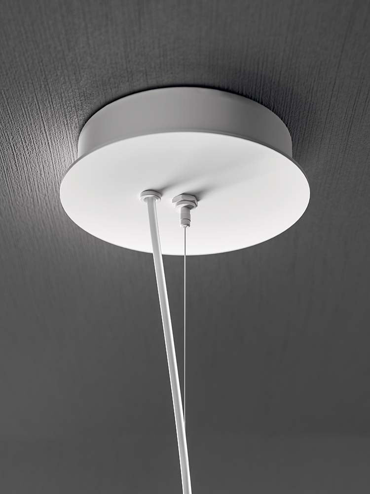 Zwarte hanglamp boven een dressoir in een donkere ruimte