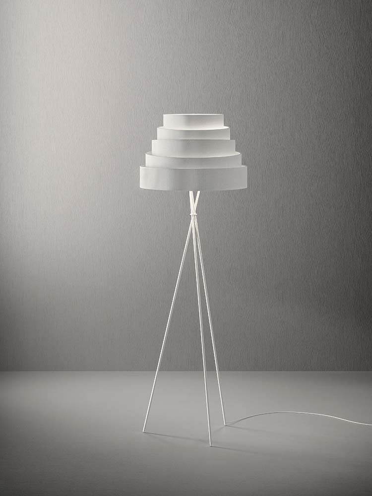 Staande lamp met witte getrapte kap op een drievoet