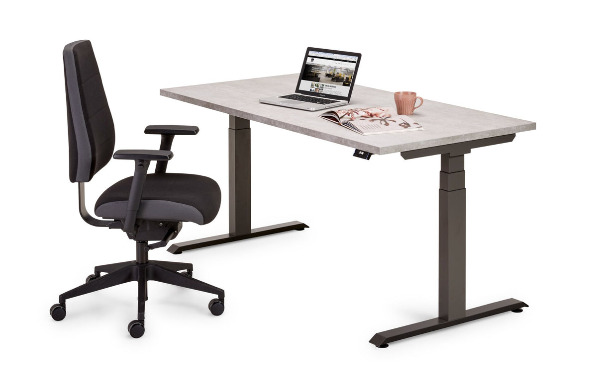 Flex 3+ zit-sta bureau met betonlook blad en donkergrijs frame, met zwarte bureaustoel en laptop