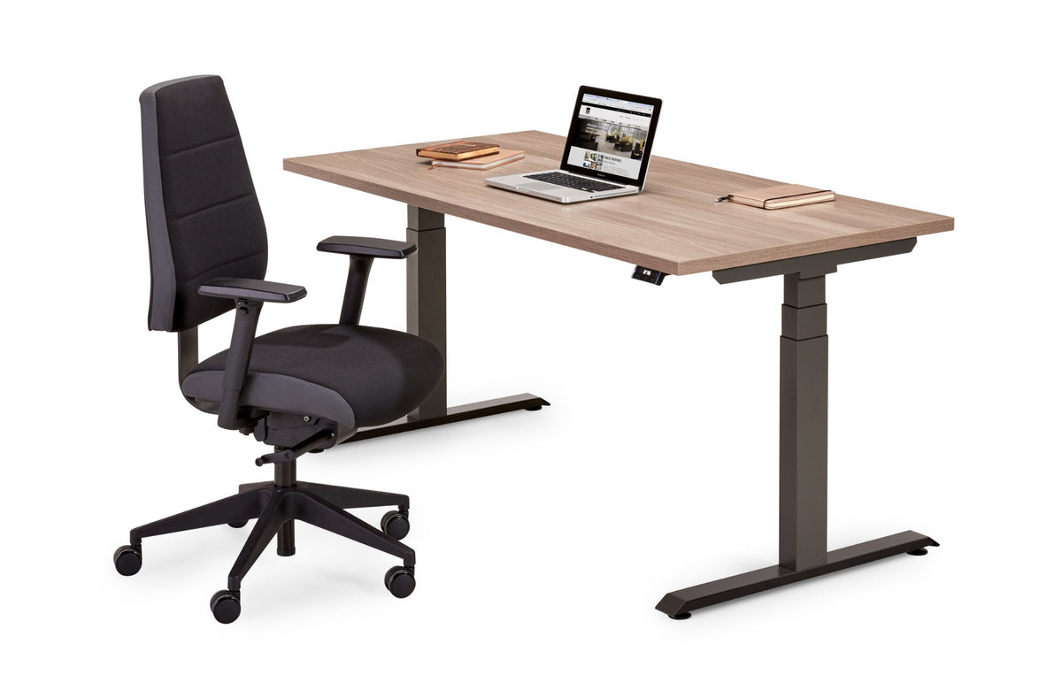 Flex 3+ zit-sta bureau met houtdecor blad en donkergrijs frame, met zwarte bureaustoel en laptop