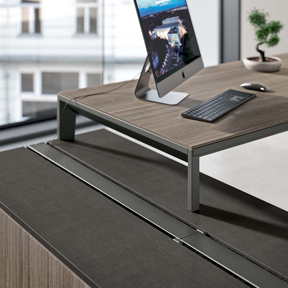 Quadrifoglio X5 directiebureau: detail van het donkere blad met metalen poot, kabelgoot en monitor