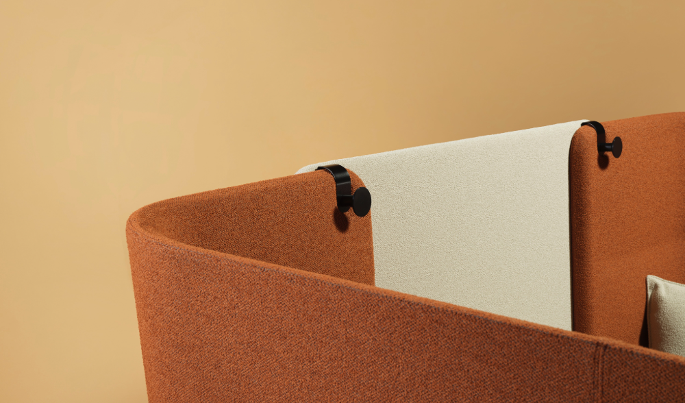Detail van de roestbruine wand van de belcel met een crèmekleurig scherm en zwarte haak