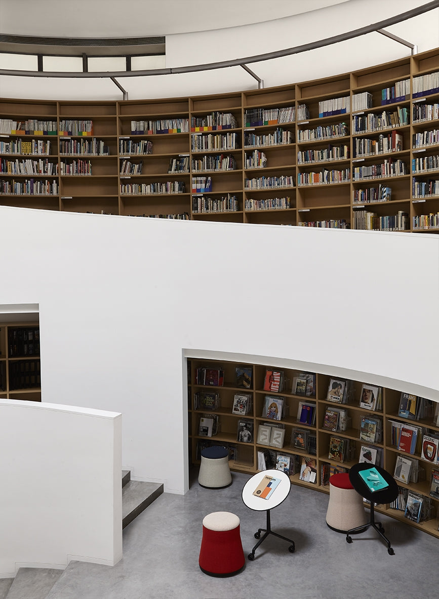 Joy poefs in een bibliotheek met ronde boekenwanden
