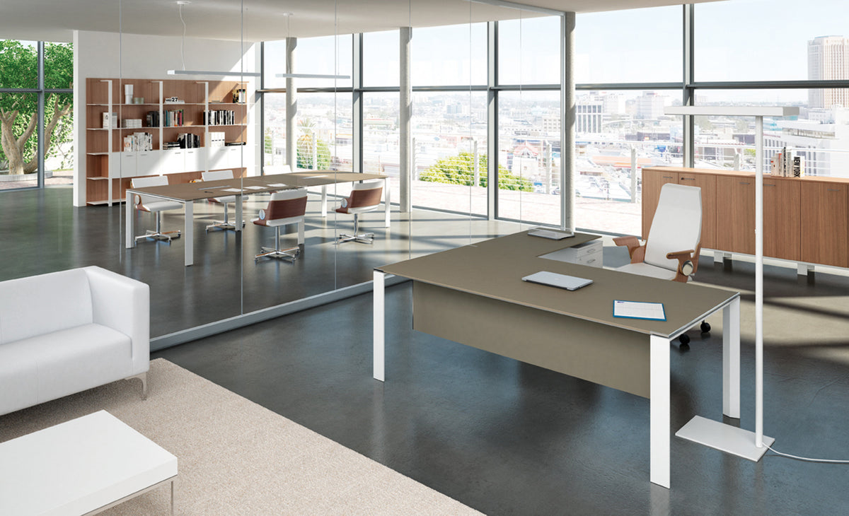 Quadrifoglio X7 directie hoekbureau in taupe met witte poten, in een kantoor met vergadertafel en bank
