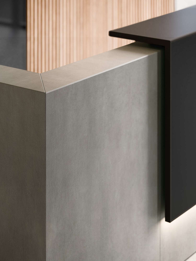 Hoekbalie in betonlook tegen een houten lamellenwand, met verlichting onder de balierand