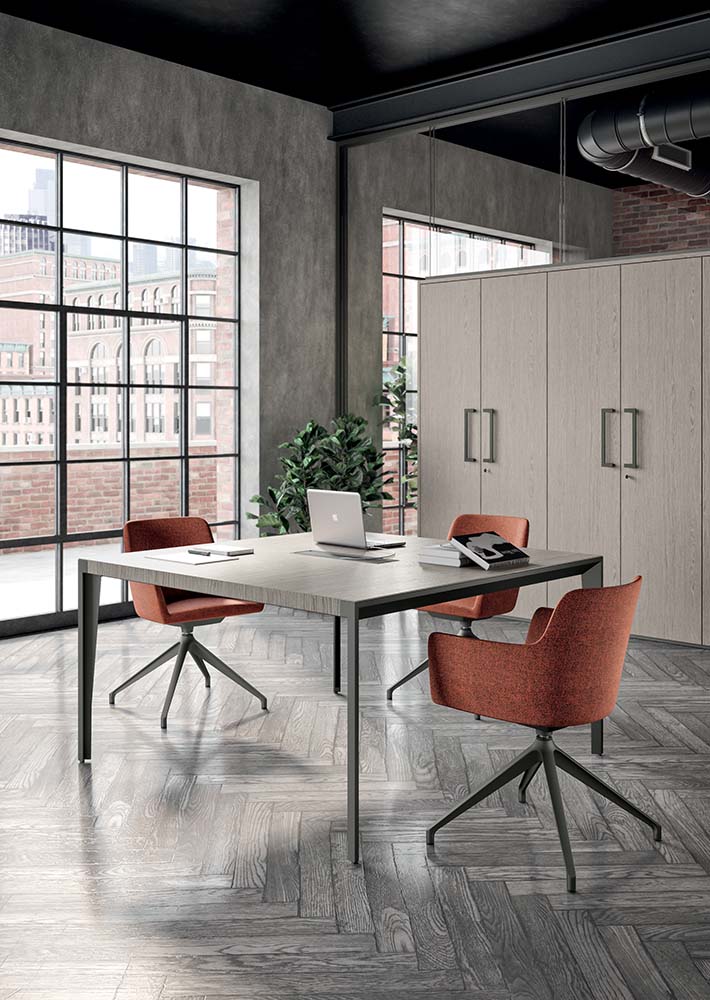 Sfeerbeeld van een X9 vergadertafel met licht blad op donkere poten, met terracotta stoelen