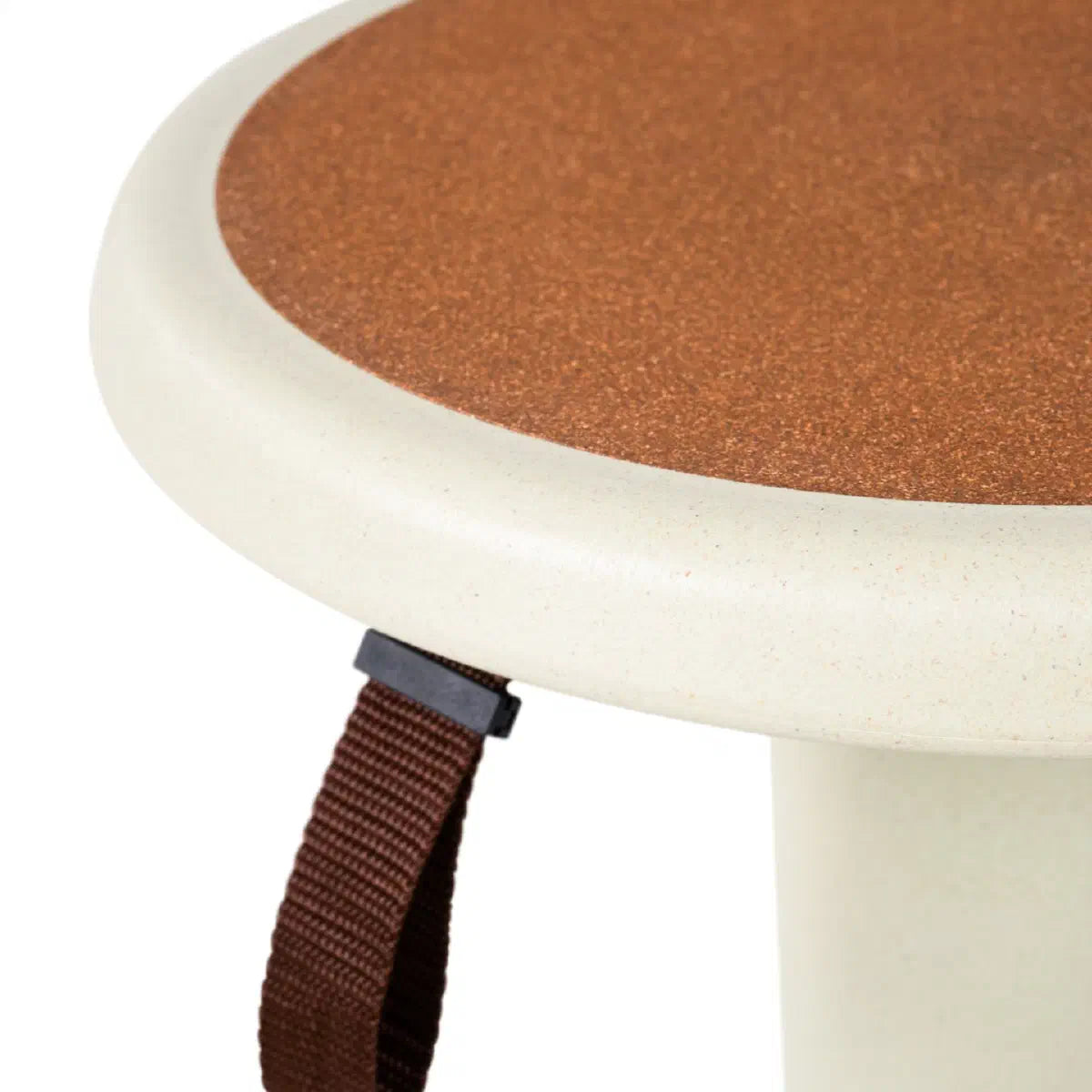 Detail van de ronde zitting met roodbruine kurkvulling, crèmekleurige rand en donkere draagband