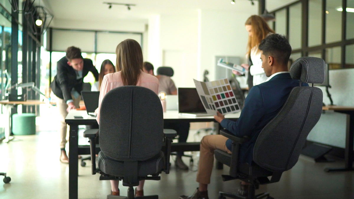 Collega's in overleg aan een tafel met bureaustoelen Therapod X Compact