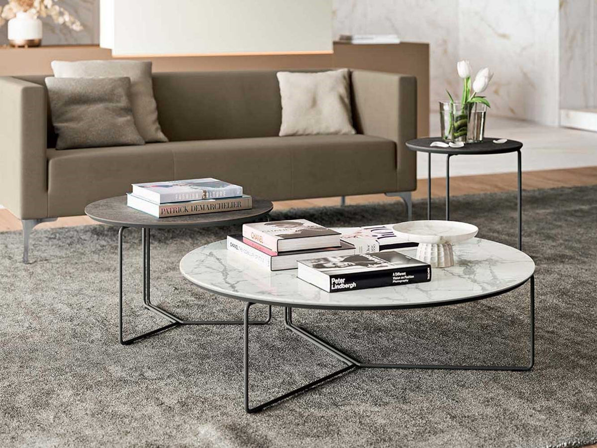 Ronde salontafel met marmerlook blad op een slank metalen frame, met een hogere bijzettafel ernaast