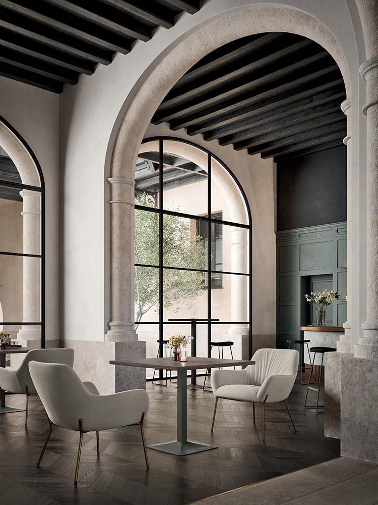 Loungehoek met fauteuils rond twee lage tafels met donker blad