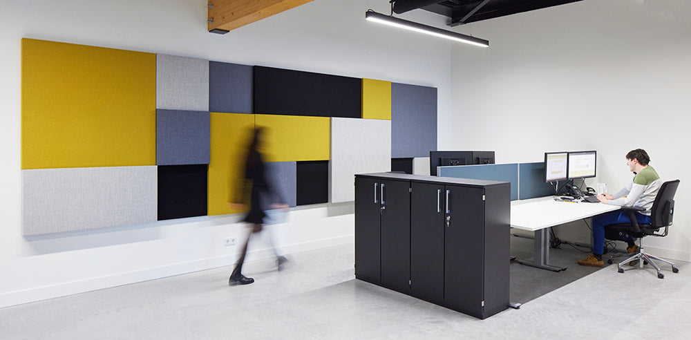 Akoestische wandpanelen in geel, grijs en blauw in een kantoor